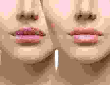 A woman 's face with pink lipstick and a small amount of pink on her lips.